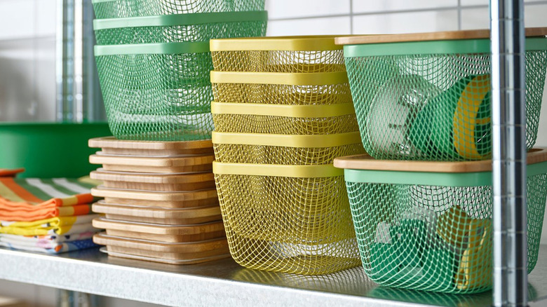 Many gree and yellow Ikea 365+ metal food storage baskets in a kitchen.