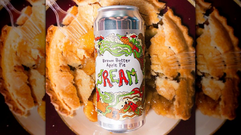 Can of Brown Butter Apple Pie JREAM with apple pie in background