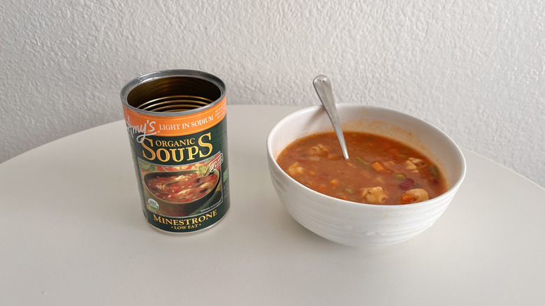 Open can of minestrone soup with a bowl