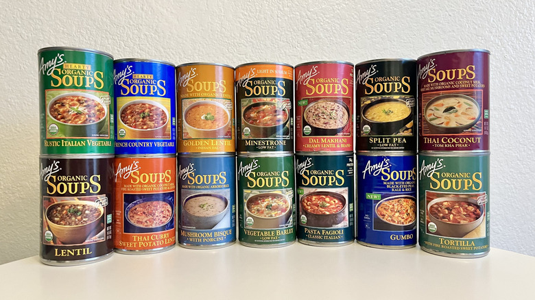 Various Amy's canned soups stacked on table