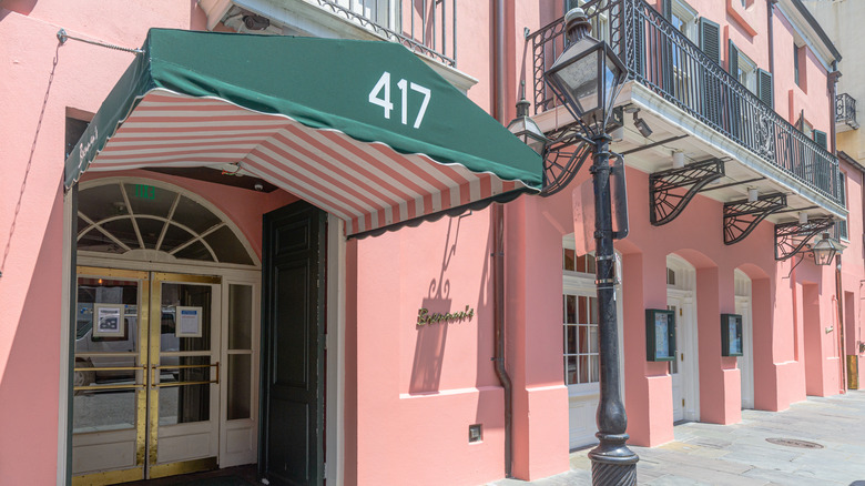 Brennan's pink-colored exterior with streetlights and iron balconies during the daytime