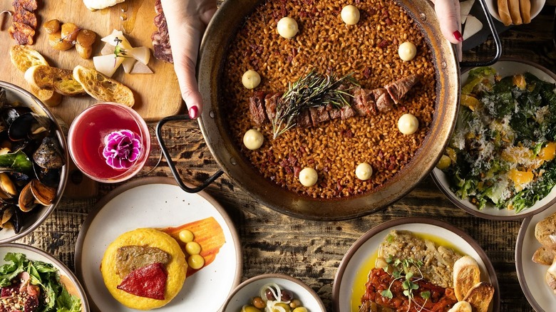 Various dishes including tapas, mussels, and salad on a table at Cúrate