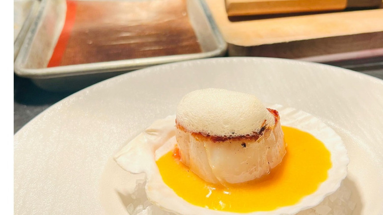 Scallop with tomato jam on a white plate at Mixtli