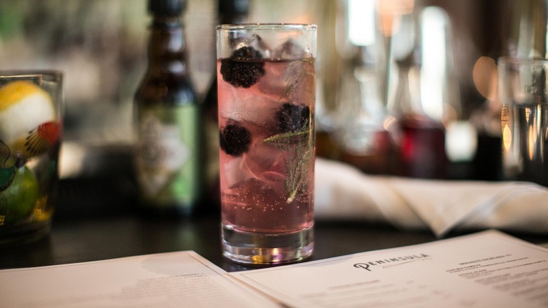 Craft berry cocktail on a table with a menu at Peninsula restaurant
