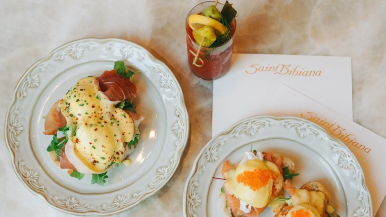 Red cocktail and plates of prosciutto eggs Benedict and salmon with caviar at Saint Bibiana