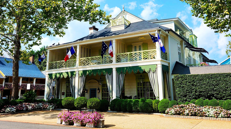 Cottage-style exterior of The Inn at Little Washington with trees and trimmed bushes