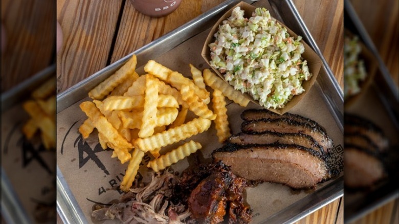 metal tray with sliced barbecue meat and French fries