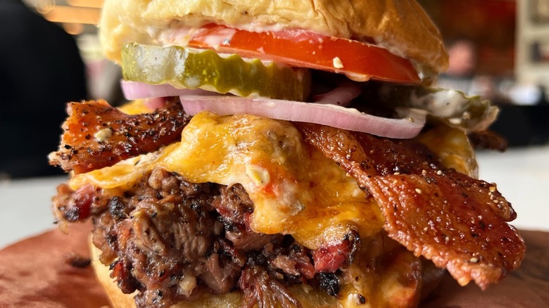 Chopped brisket burger with pimento cheese, bacon, onion, pickle, and tomato