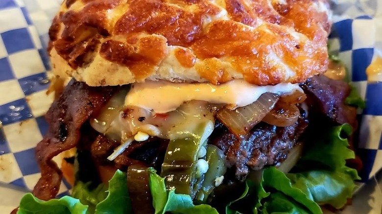 Burger with cheese, onions, lettuce, and sauce