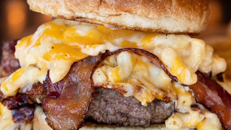 Close-up of mac attack burger with mac and cheese, bacon, and burger