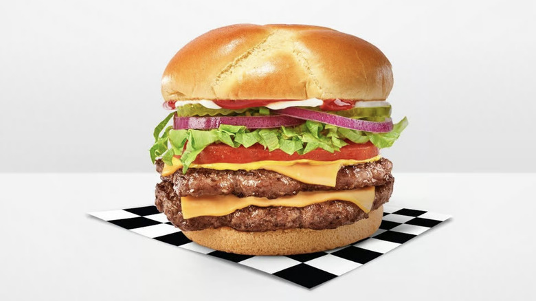 Checkers & Rally's Big Buford burger on a piece of black and white checkered parchment paper