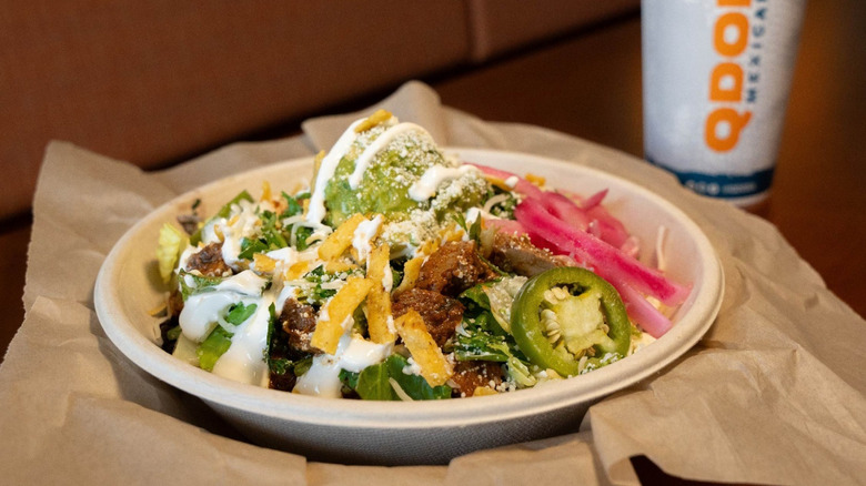 Plate of food from Qdoba with a soda cup in the background