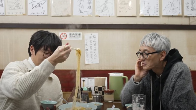 Sung Si-kyung and Yutaka Matsushige sitting at table with noodle dishes