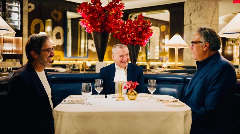 Ray Romano, Brad Garrett, and Phil Rosenthal at a table at fancy restaurant