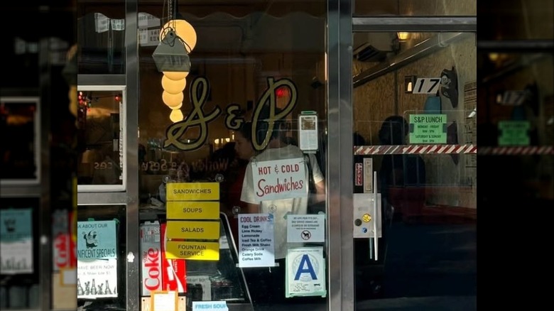 Exterior of S&P lunch restaurant in NYC with glass doors and signs