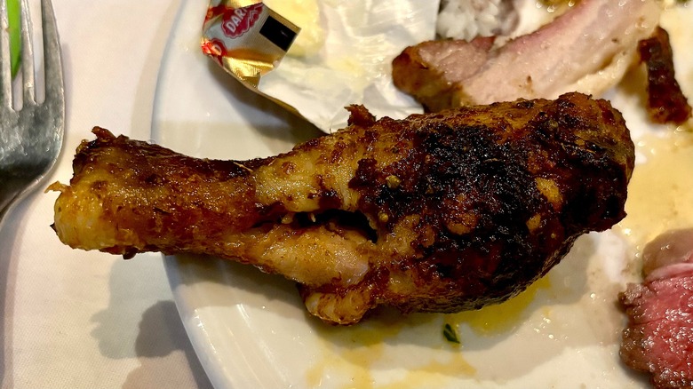 Chicken leg on white plate at Fogo de Chão