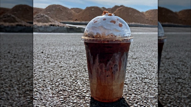 Iced coffee sitting on the road in the sun