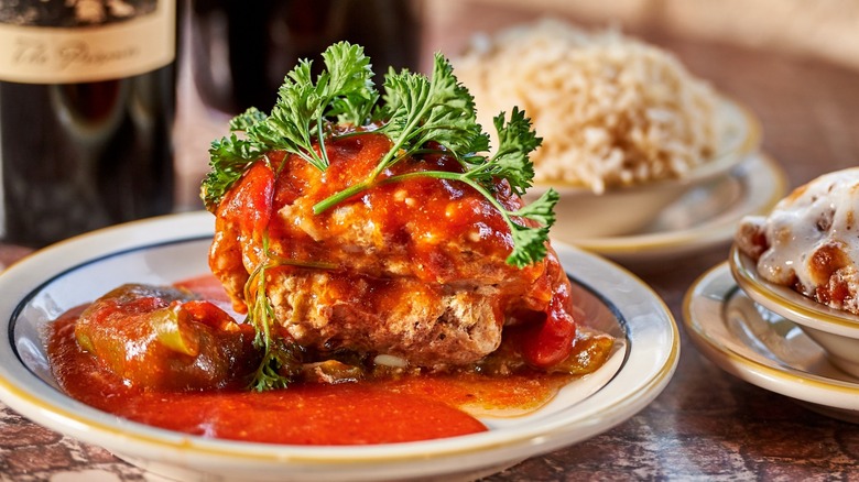 Stuffed pepper with sauce with several other plates and dishes