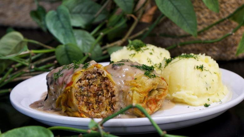 Cabbage rolls and mashed potatoes on plate with greenery
