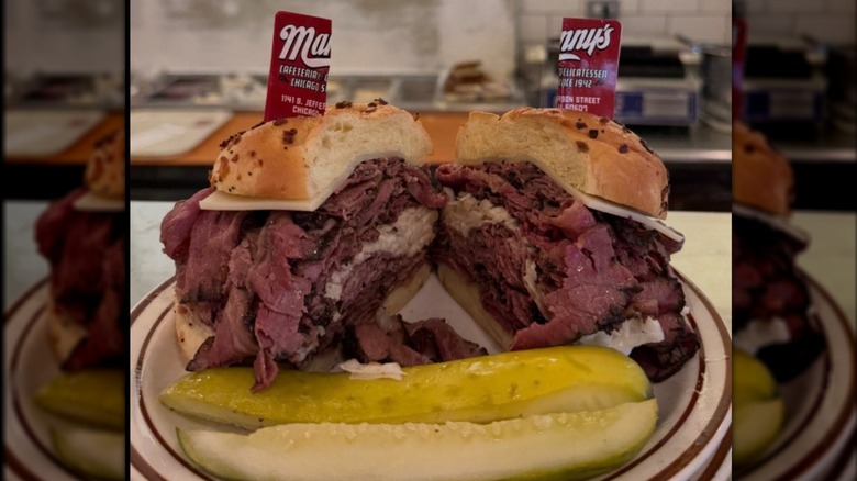 Pastrami and coleslaw sandwich on plate with pickles