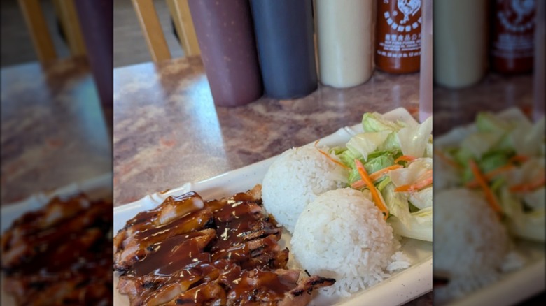 Plate of teriyaki with two scoops of rice and salad
