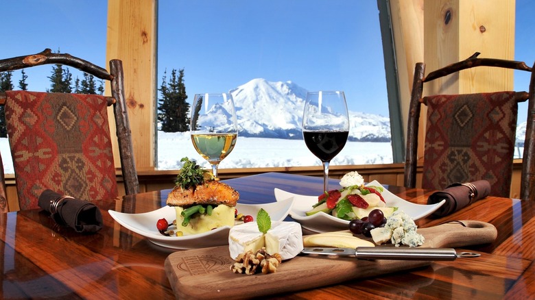 Cheese and wine meal with view of snowy mountain at Summit House Restaurant