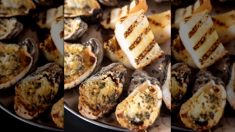 Char-grilled oysters on tray with garlic bread