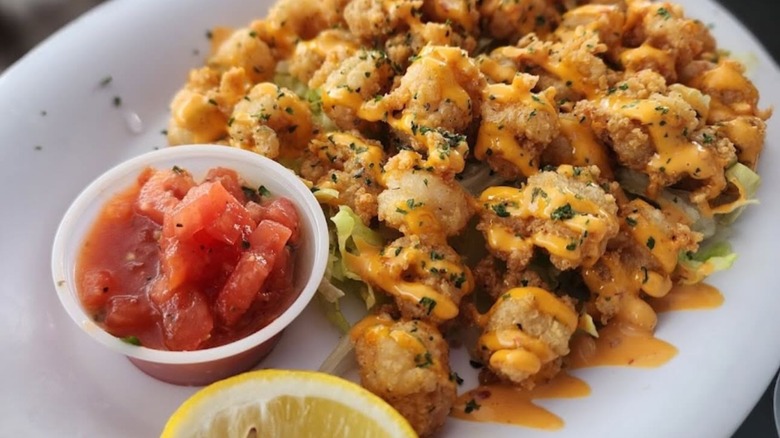 Plate of fried shrimp with sauce, pico, and lemon wedge