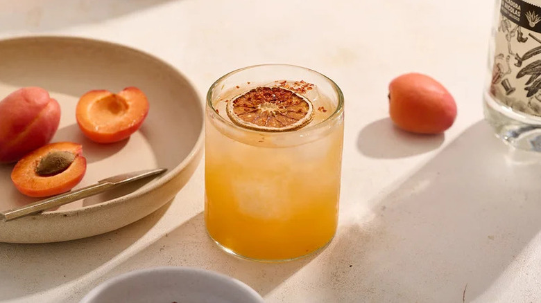 Hot honey apricot margarita in glass, garnished with dried orange slice