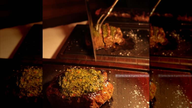 Whole steak on a tray with second being sliced in the background