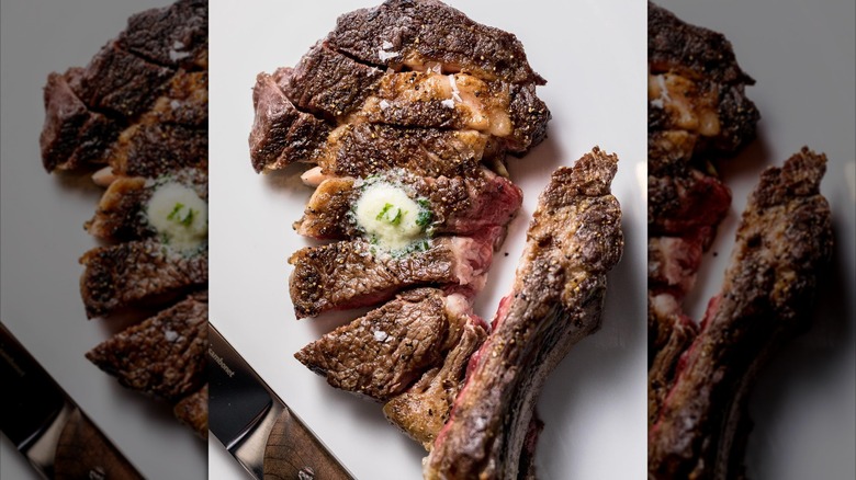 Sliced steak with butter on white plate