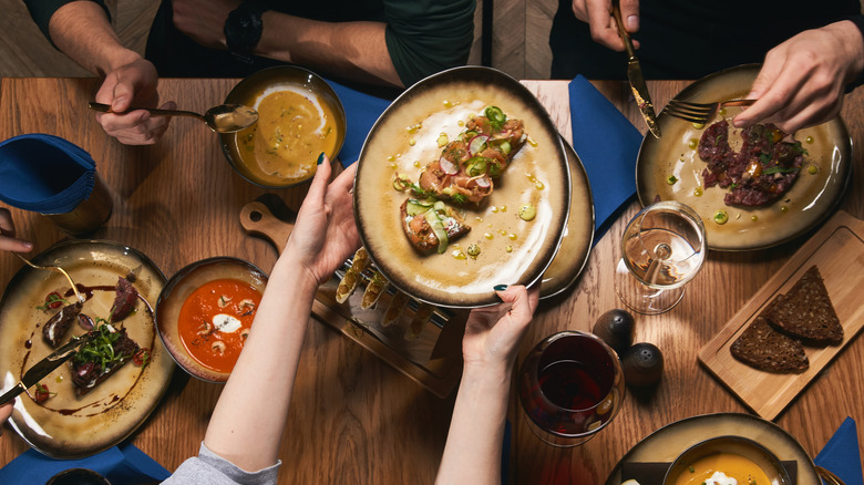 Top view of passing plates across the table at steak restaurant
