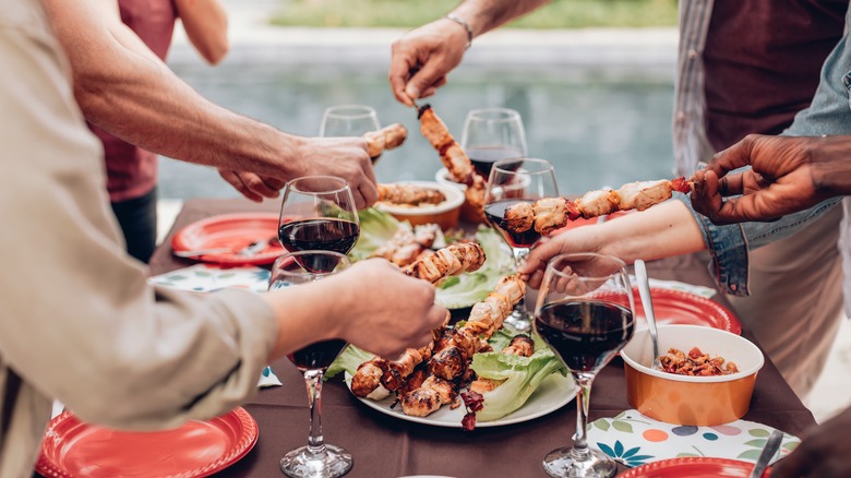 table with barbecue skewers and wine