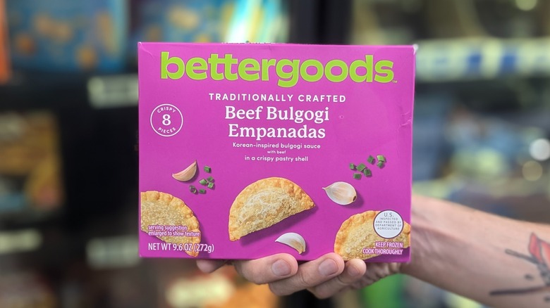 A hand holds a purple box of beef bulgogi empanadas