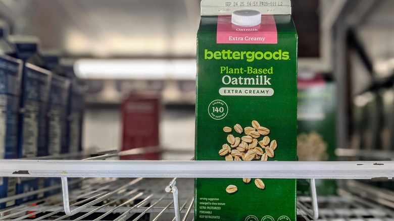 A carton of extra-creamy oat milk in a mostly-empty refrigerator at Walmart
