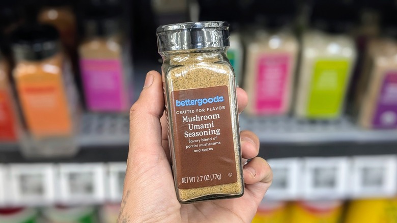 A hand holds a small jar of mushroom umami seasoning at Walmart