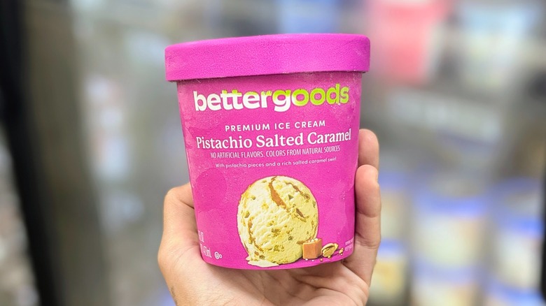 A hand holds a purple pint of bettergoods brand ice cream