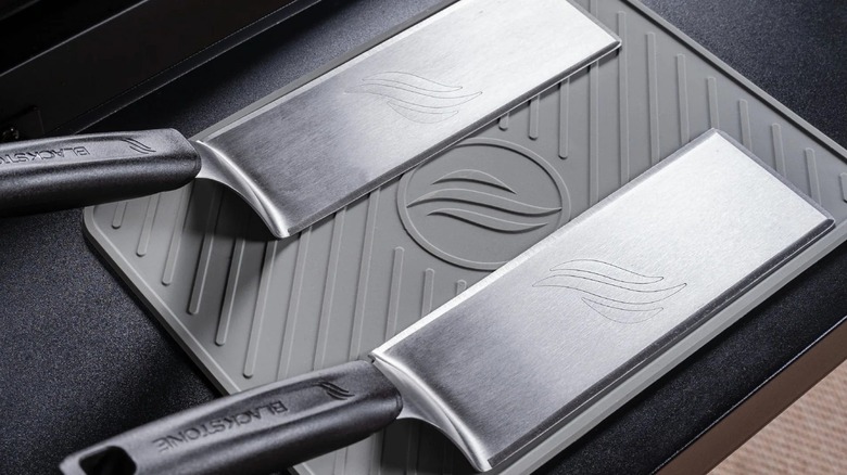Two Blackstone spatulas resting on a Blackstone Griddle Tool Mat