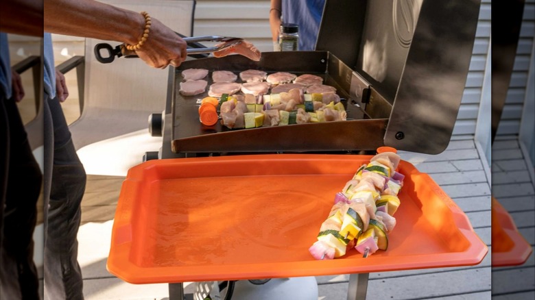 Orange Blackstone Serving Tray is sitting on the side of a Blackstone griddle