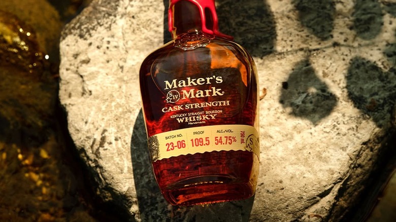 A top down shot of a bottle of Maker's Mark Cask Strength laid on a large rock
