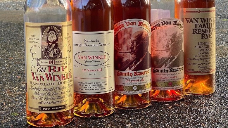 A close shot of five different bottles from Old Rip Van Winkle placed on the floor
