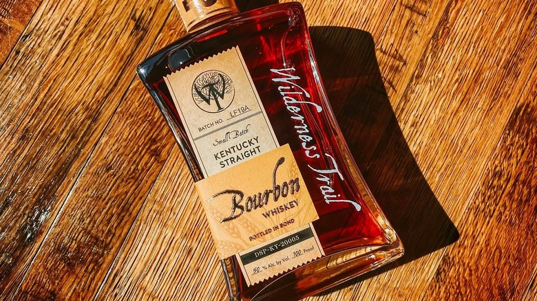 A top-down shot of Wilderness Trail Wheated Bourbon laid down on a wooden surface
