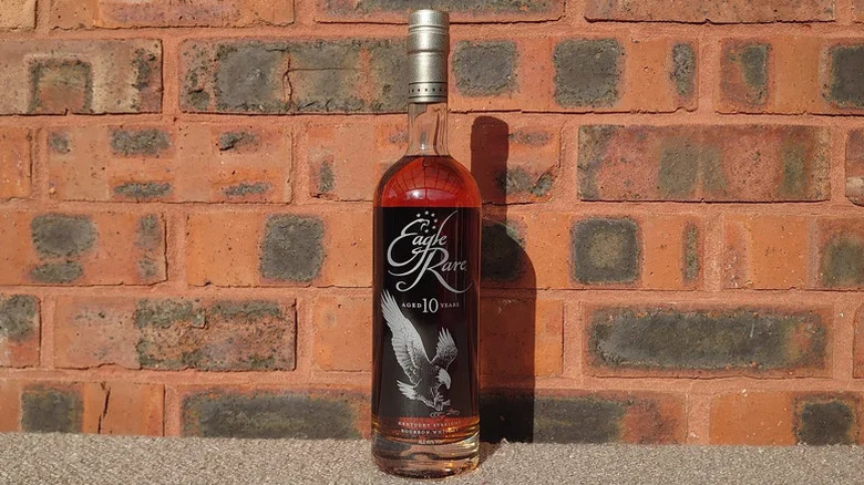 A bottle of Eagle Rare 10-year posed in front of a red brick background