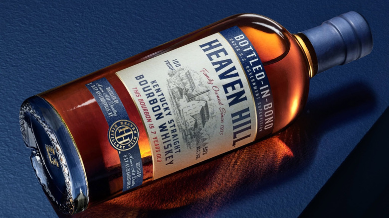 A bottle of Heaven Hill laid on its side on a brightly colored table