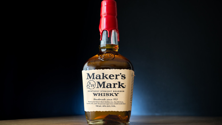 A stylized product shot of a bottle of Maker's Mark in front of a dark background