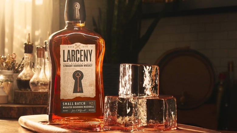 A bottle of Larceny Small Batch on a table next to three huge ice cubes