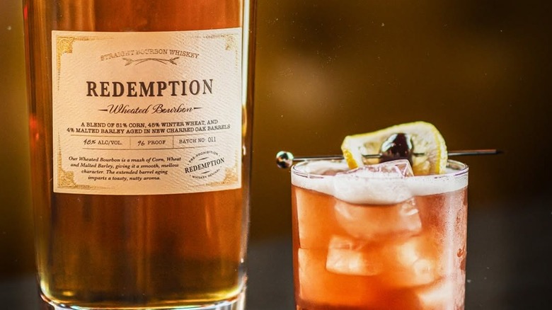 A close up of a bottle of Redemption Wheated Bourbon next to a cocktail