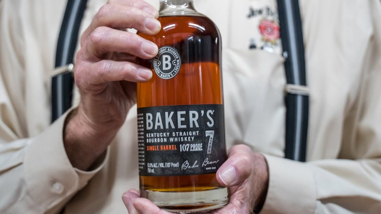 A person holding up a bottle of Baker's 7-year single barrel up to the camera