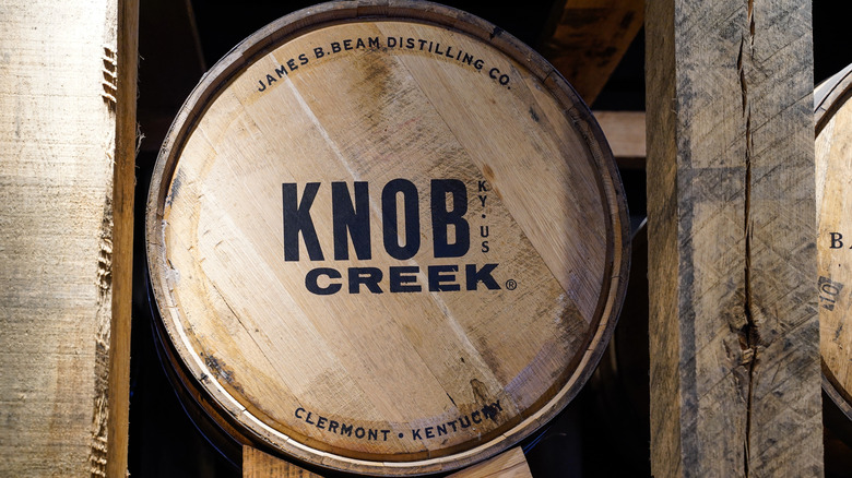 A barrel of Knob Creek bourbon shown in a warehouse, with its distiller and location also shown