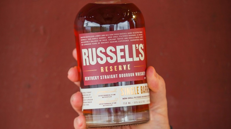 A person holding a bottle of Russell's Reserve Single Barrel up to the camera